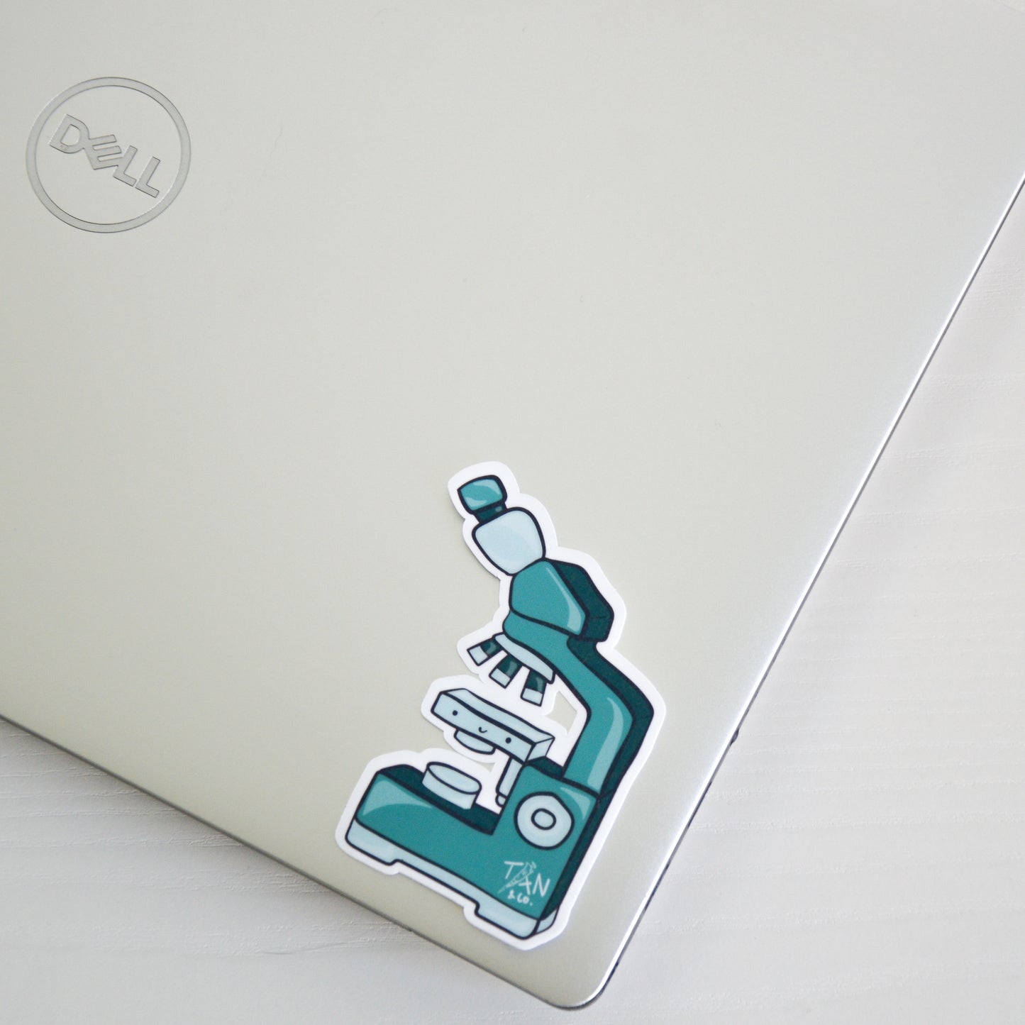 Green microscope sticker on laptop