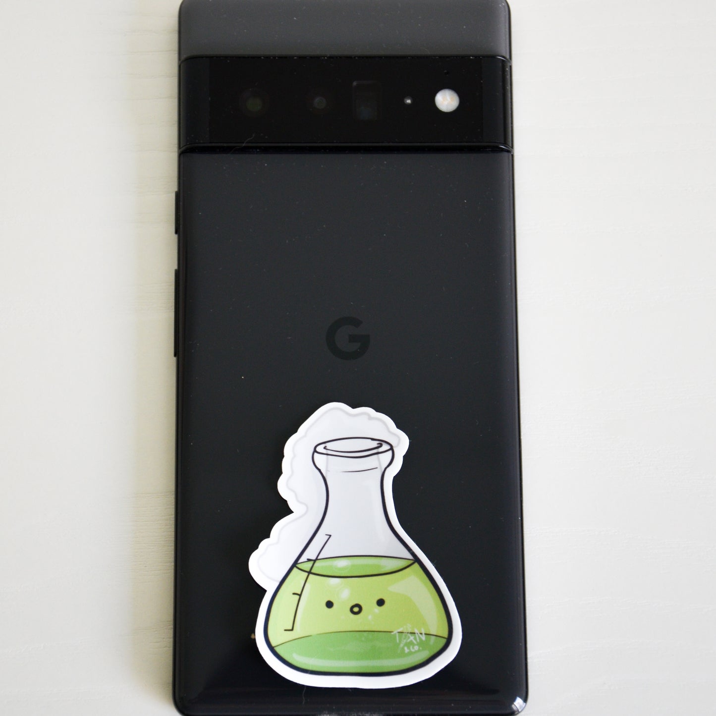 Green conical flask sticker on phone