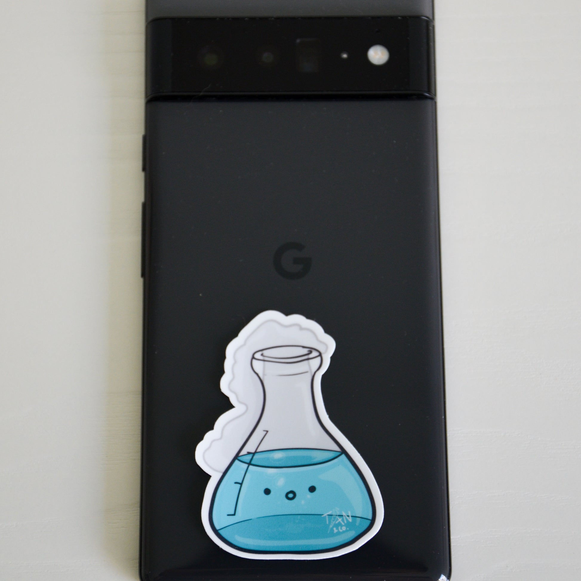 Teal conical flask on phone