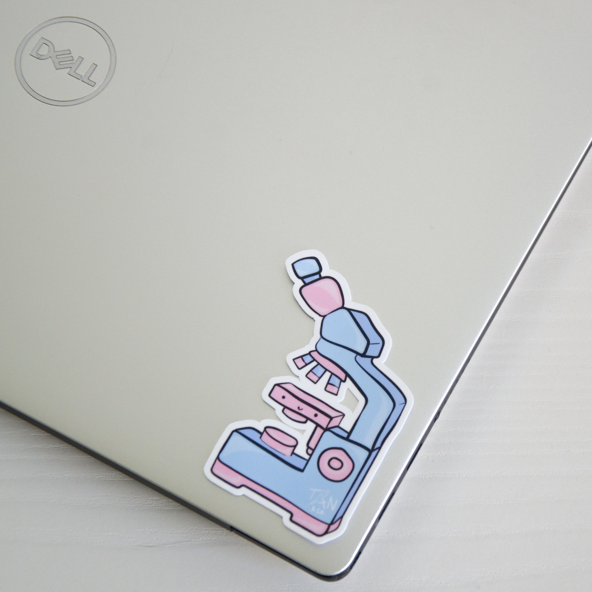 Pink and blue microscope sticker on laptop