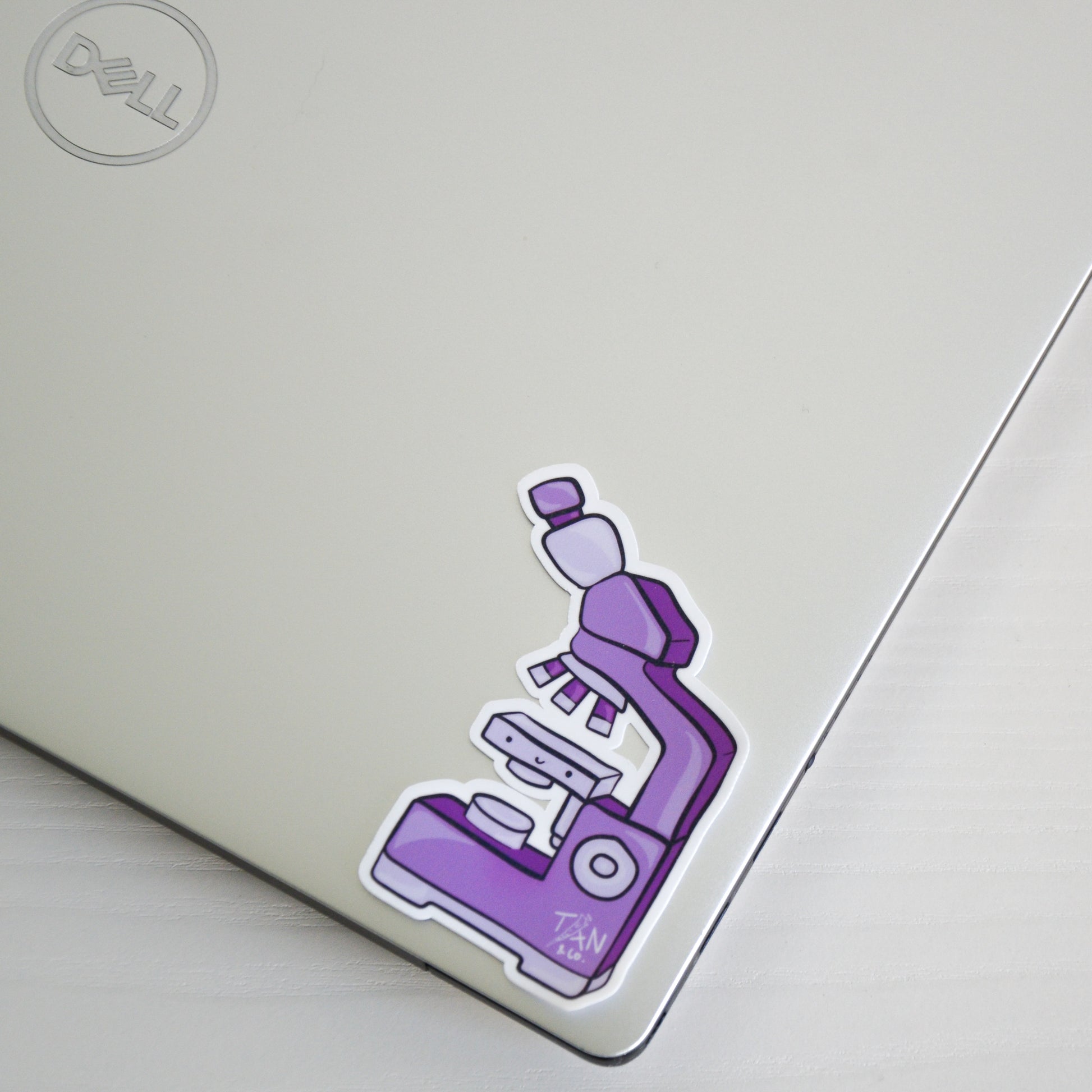 Purple microscope sticker on laptop